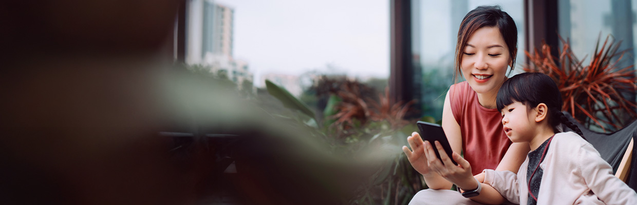 一位女士坐在地上，拿著咖啡，使用著電腦; 圖片使用於滙豐台灣優利定存優惠專案的頁面。